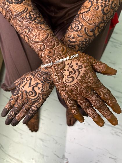 A close-up of the palms, showing the initials 'V' and 'F' and the name 'Maryam' in Arabic script.