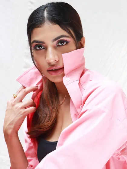 A creative makeup look with a focus on pink tones for a Dani Clothing shoot. The graphic eyeliner and soft pink hues create a cohesive and artistic fashion statement.