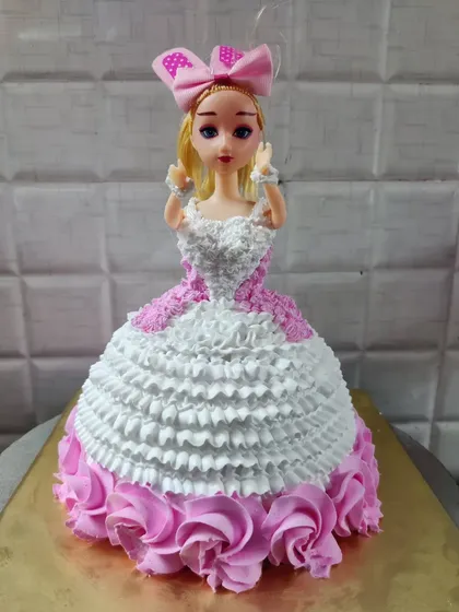An elegant doll cake featuring a white and pink gown with delicate ruffles. These cakes are always a showstopper at birthday parties.
