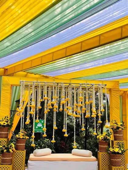 The colorful striped canopy creates a festive and cheerful atmosphere for this Haldi celebration.