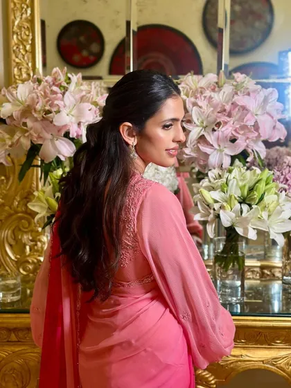A back view of the pink Manish Malhotra saree, showing the elegant hairstyle and the beautiful drape of the fabric.