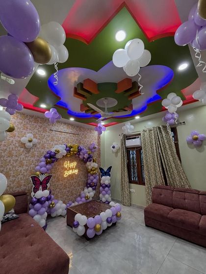 A full room view of a butterfly-themed home decoration. This shows how we can transform a living room with a central balloon arch and smaller balloon details on the ceiling and walls.