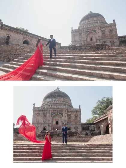 A dramatic, sweeping shot at a historic Delhi monument, with the bride's vibrant red dress flowing in the wind. We use grand architecture to frame your love story, creating powerful and timeless portraits.
