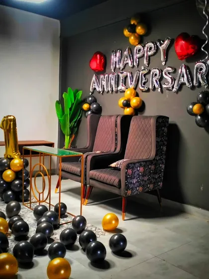 A stylish and modern first-anniversary decoration. The black and gold theme, "Happy Anniversary" foil balloons, and a large "1" balloon make for a chic and celebratory corner.