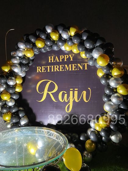 A detailed shot of the balloon arch for the retirement party, showcasing the mix of black, chrome gold, and silver balloons for a professional look.
