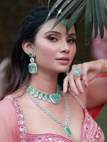 A fresh, blushy, and natural look perfect for any special day. The soft pink tones in the makeup beautifully complement the emerald and diamond jewelry.