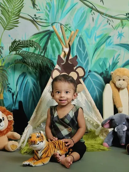 A little explorer in our jungle safari setup. Surrounded by plush animals like a lion, tiger, and panda, this theme is perfect for adventurous kids.