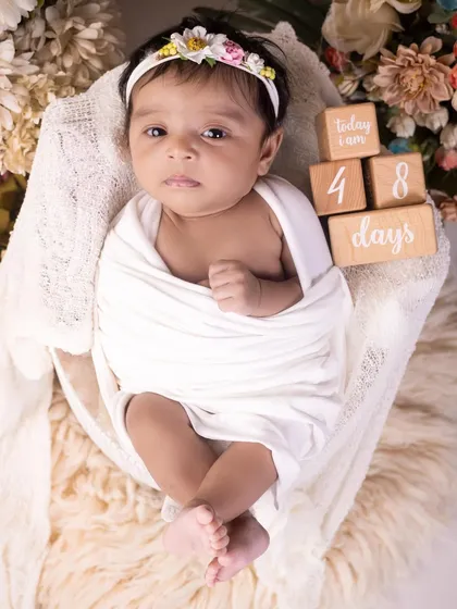 At 48 days old, this baby is alert and making eye contact. I love capturing these moments of connection, showing your baby's awareness of the world around them.