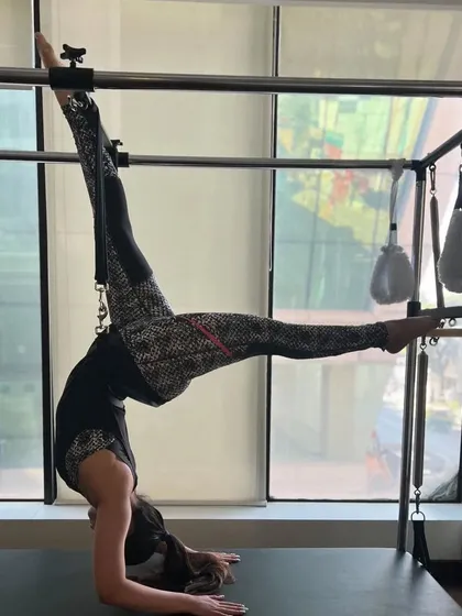 An advanced inversion on the Cadillac, requiring significant core strength, balance, and flexibility.
