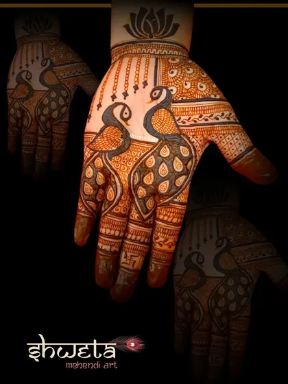 A bold and beautiful peacock design for the palm. The use of negative space makes the two peacocks the central focus of this striking piece of henna art.