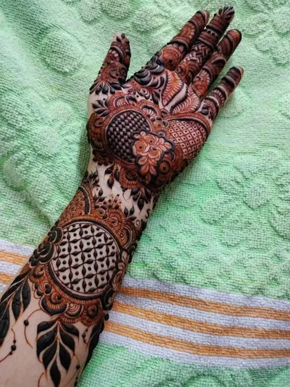 This design combines circular mandala patterns with geometric grids and leafy vines, creating a rich and varied look for a bride.