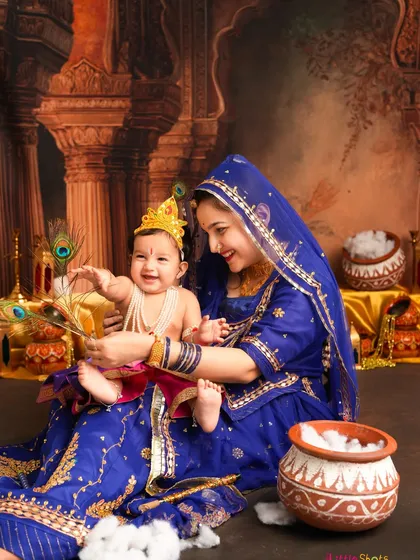 A playful moment during a Janmashtami shoot, with little Krishna reaching for a peacock feather held by his mother. These candid interactions bring so much life to the photos.