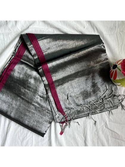 This silver tissue cotton saree with a magenta border is another versatile piece. It would look stunning with a simple black blouse or a rich magenta one.