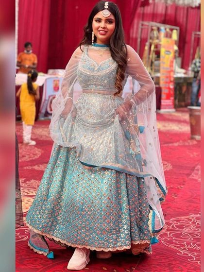 A fun, full-length shot of the light blue floral lehenga, showing how it can be styled with sneakers for a modern and comfortable twist.