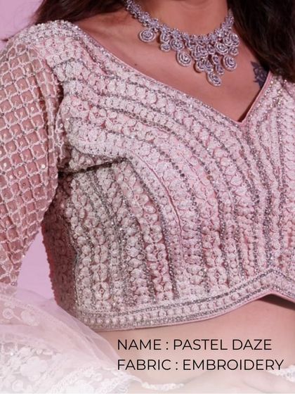 A close-up of a pastel embroidered blouse, showing the delicate beadwork and soft color palette.