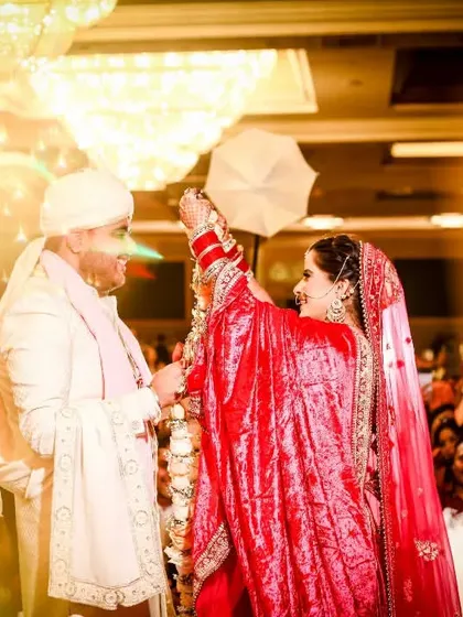 Your grand entrance as a married couple should be nothing short of spectacular. Here, I captured the exact moment of celebration with dramatic lighting and a cloud of smoke, making their Jaimala ceremony feel like a scene from a fairytale.