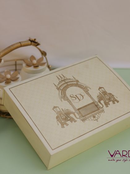 A minimalist yet elegant wooden box featuring a laser-etched design of a royal procession with a custom monogram. This design offers a modern take on traditional Indian wedding motifs.
