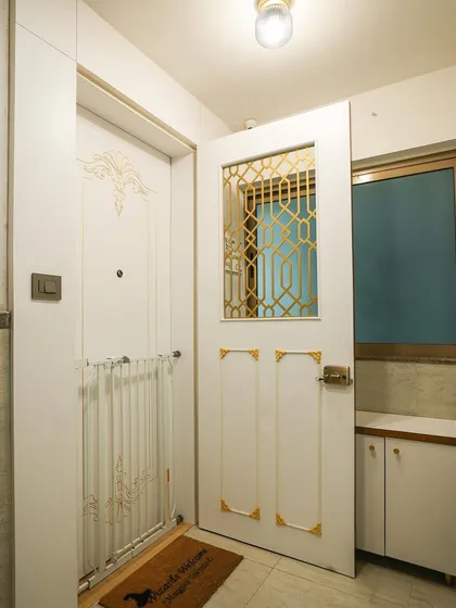A full view of the white and gold door combination. The addition of a child safety gate shows how we can integrate practical family needs into our designs without compromising on style.