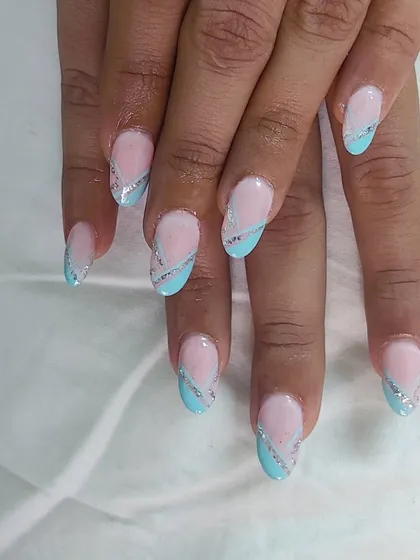 A modern design with a light blue color block and a delicate silver glitter line on a nude base. This shows how glitter can be used for sharp, graphic details.