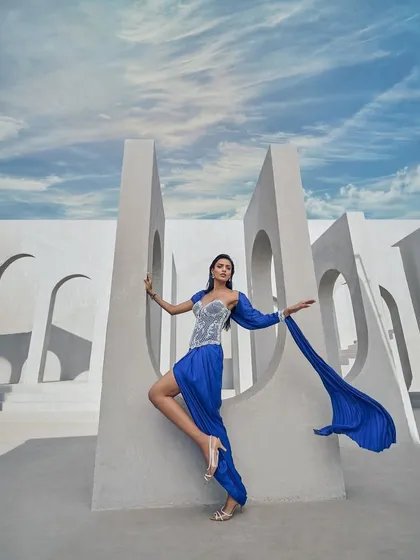 A pre-draped sari in a striking active blue hue, crafted from crushed fabric and elevated with delicate pearl embellishments. A statement in motion, designed for the contemporary muse.