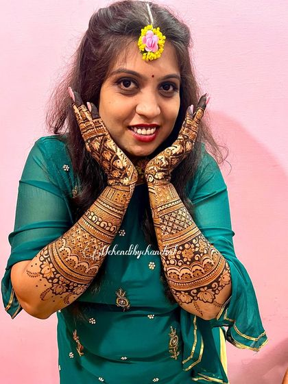 A beautiful, smiling bride showing off her intricate henna. This is the happiness I strive to create for every client.