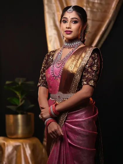 This modern reception look showcases a stylish drape on a pink and brown silk saree, paired with contemporary diamond jewellery. I can adapt my draping style to match the vibe of your event and outfit perfectly.