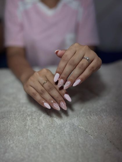 A soft pink base with delicate white leaf-like line work. This minimalist design is elegant and perfect for clients who prefer subtle art.