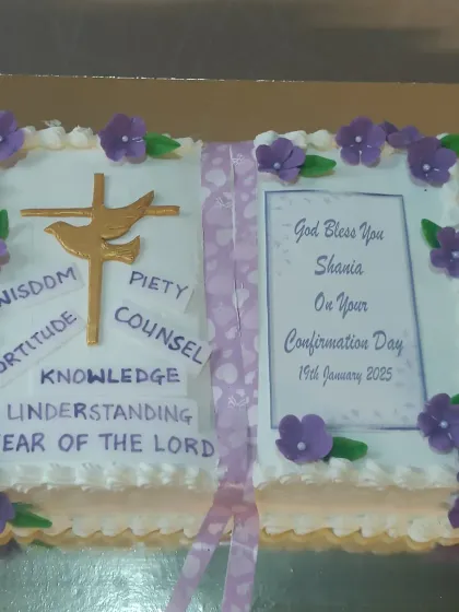 A confirmation cake in the shape of a holy book. This design is personalized with the seven gifts of the Holy Spirit.