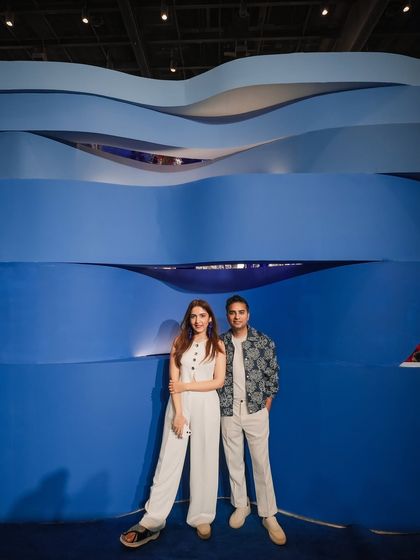 The layered, wave-like wall served as a dramatic backdrop and a key architectural feature. Its organic form contrasts with the sleekness of the chrome, adding another layer of visual texture to the installation.