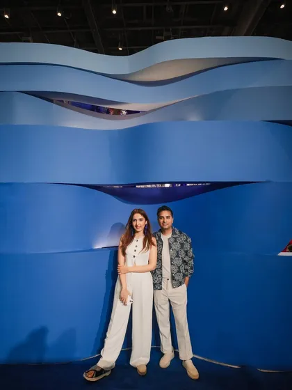 The layered, wave-like wall served as a dramatic backdrop and a key architectural feature. Its organic form contrasts with the sleekness of the chrome, adding another layer of visual texture to the installation.