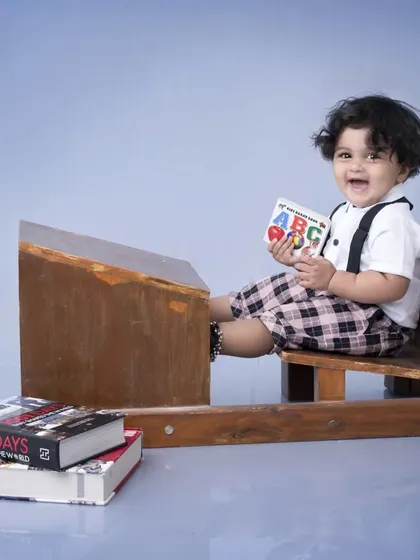 A happy little student at his desk, laughing as he holds an ABC book. This theme is a wonderful way to capture the excitement of learning and growing up.