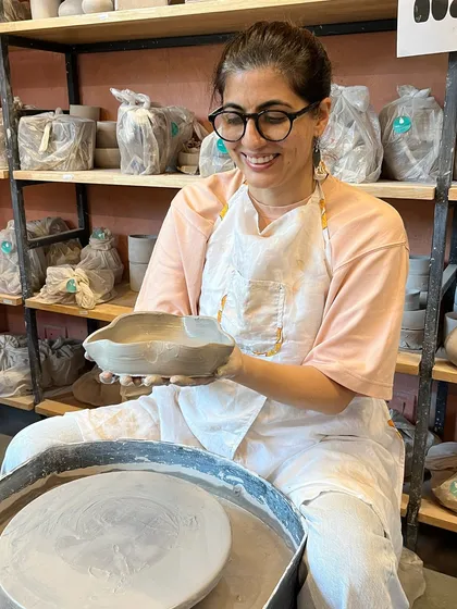 Look at that beautiful, organic shape. A student in our foundation course proudly holds up a bowl she crafted, showcasing the skills she's learned.