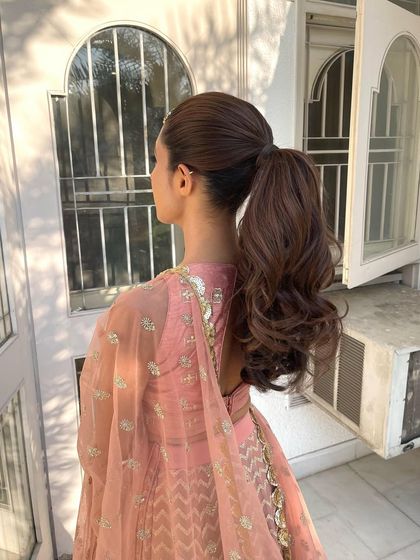 A side view of the wavy high ponytail. The sleekness at the crown contrasts beautifully with the soft waves of the ponytail.