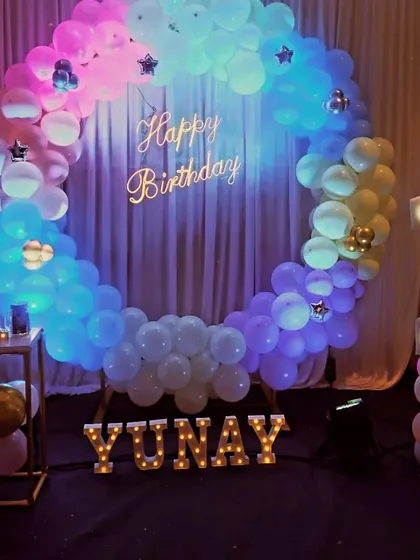 A stunning pastel-colored balloon ring with a neon sign and marquee letters, creating a dreamy photo corner for the party.