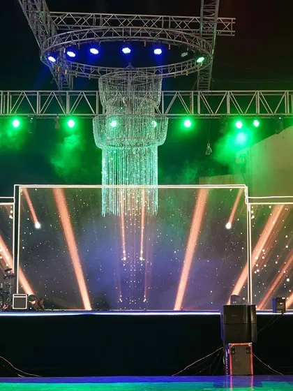 A large crystal chandelier serves as the stunning centerpiece for this sangeet stage. Combined with the LED backdrop and professional lighting, it creates a look of pure opulence.