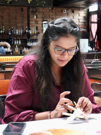 A participant carefully tying her fabric. The precision and care taken at this stage are what lead to clean, beautiful patterns in the final product.