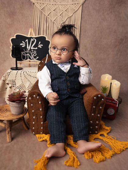 This little gentleman is looking so dapper with his tiny glasses and serious expression. The 'halfway to one' milestone is a perfect time to capture their unique personality.