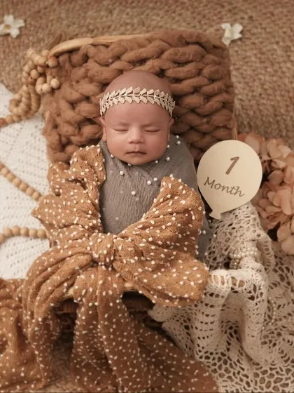 Celebrating a baby's one-month milestone with a beautifully styled photoshoot. I use soft, natural textures like chunky knits, lace, and wooden beads to create a gentle, bohemian look.