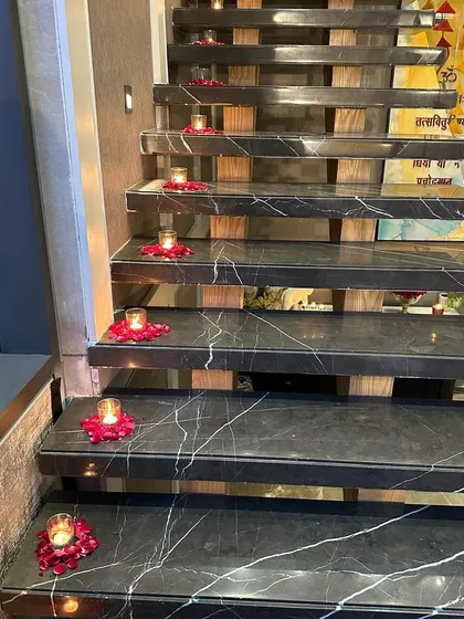 Small details make a big impact. We placed small candles in beds of rose petals along the steps of this marble staircase, lighting the way for guests and adding to the home's festive feel.