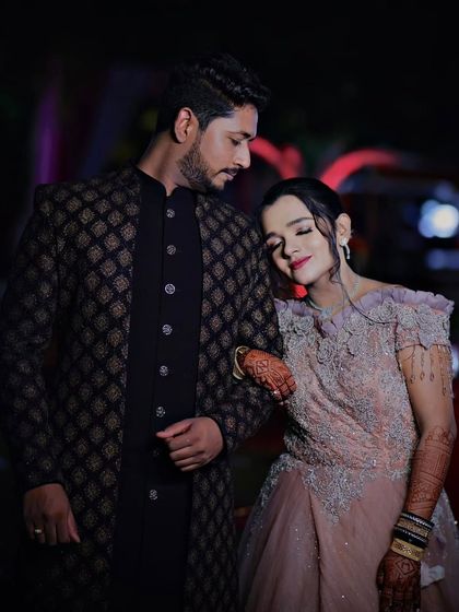 This couple chose a soft, romantic theme. Her pastel gown with delicate embroidery is beautifully paired with his dark, patterned Jodhpuri suit for a modern reception look.