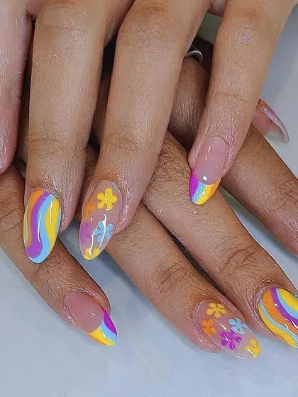 A full set of colorful rainbow and floral nails, perfect for a retro vibe.