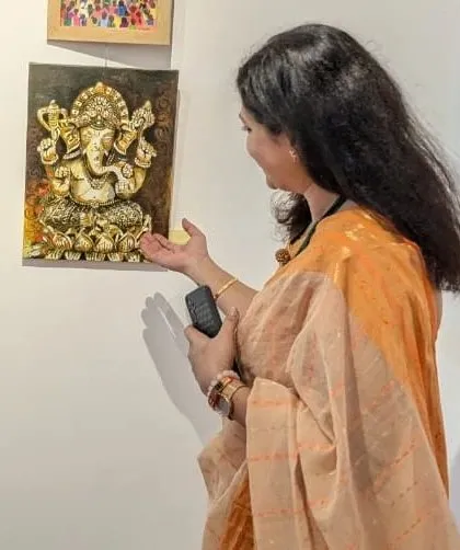 A visitor admiring my 'Panchaloha Ganesha' painting at the exhibition. The 3D texture and metallic finish are best appreciated in person.