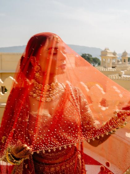 A beautiful shot of Shree through her delicate red veil, dotted with tiny pearls. This captures the soft, romantic essence of her wedding day style.