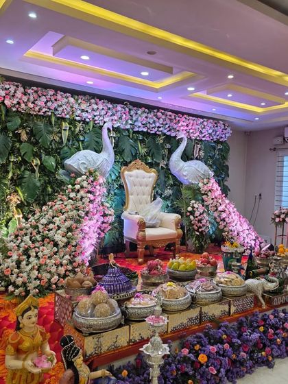An angled view of the peacock-themed stage, showing the intricate floral work on the peacock tails.