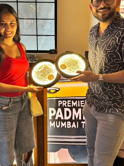 A couple holding up the matching moon lamps they created. Our workshops offer unique projects like this for a truly special date night.