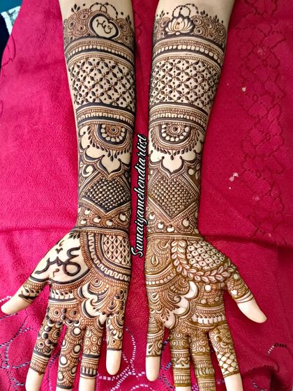 A traditional bridal henna design with full coverage. I love the symmetry and the classic motifs like checks and paisleys, with the couple's initials hidden within the pattern on the back of the hand.