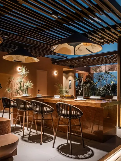 A close look at the outdoor kitchen entertainment zone at Terra Gardens. The monolithic bar, crafted from sandalwood traver onyx marble, serves as a functional centerpiece, showcasing our commitment to using natural, earthy materials that are both beautiful and timeless.
