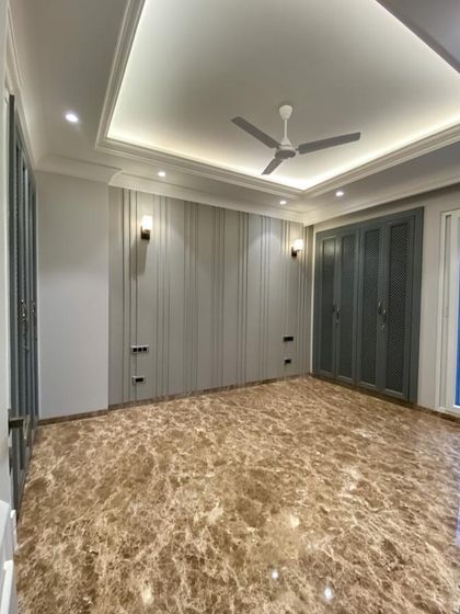A beautiful bedroom in our C-926 project. This room features rich brown Italian marble flooring, elegant grey wall paneling, and custom-built wardrobes, creating a luxurious and comfortable retreat.