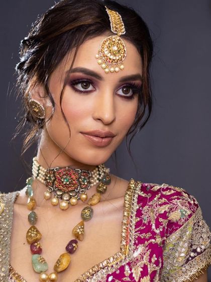 A close-up of a regal bridal look with a purple smokey eye. The makeup is rich and dramatic, perfect for an evening wedding.
