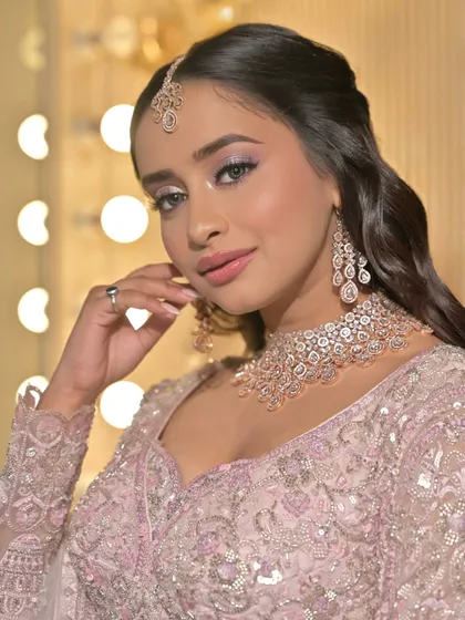 This is a perfect example of a soft glam look for a Sangeet or reception. The focus is on luminous skin, soft pastel eyeshadow, and a delicate pink lip, creating an elegant and modern bridal style.